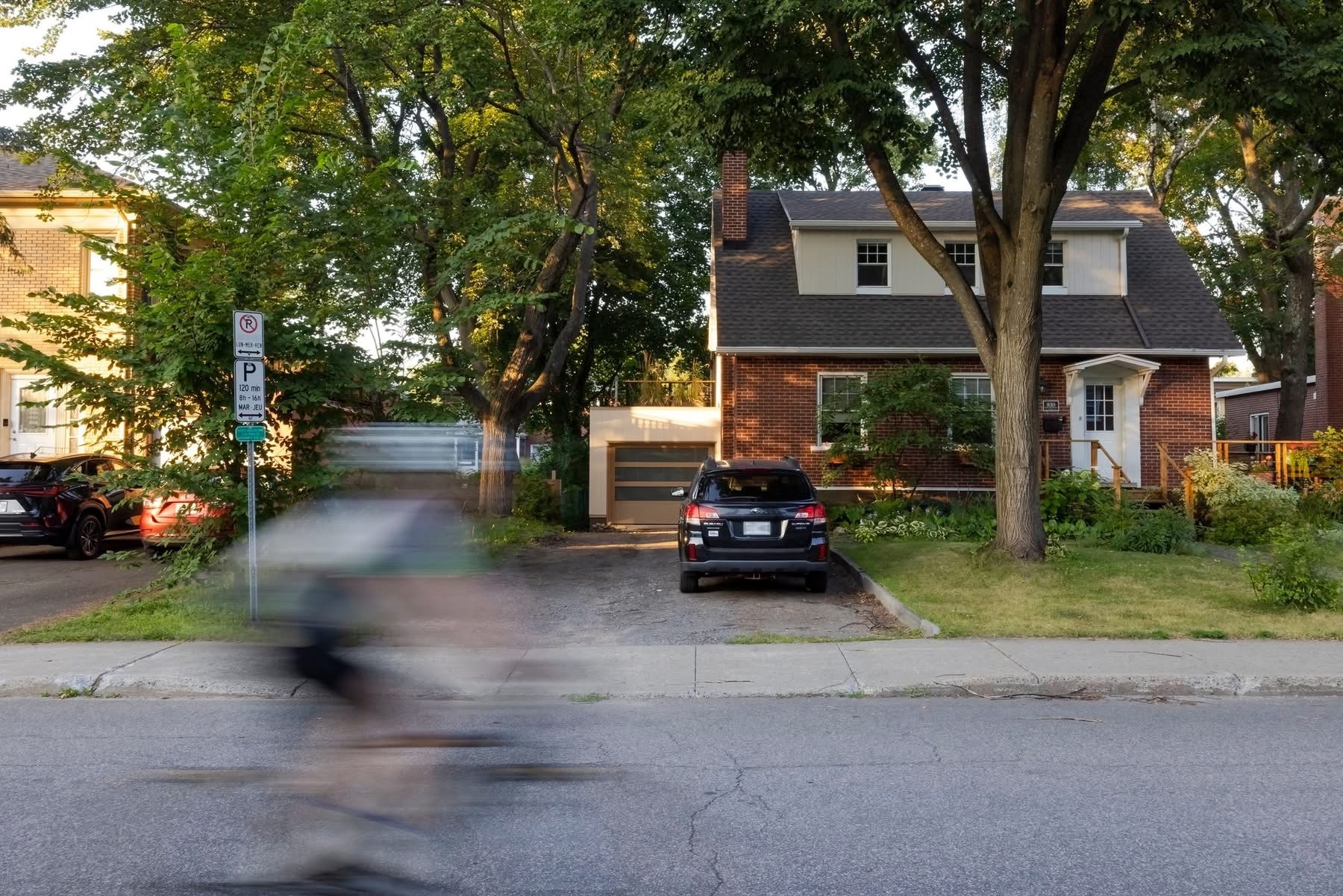 Maison en brique dans une rue résidentielle arborée de Québec