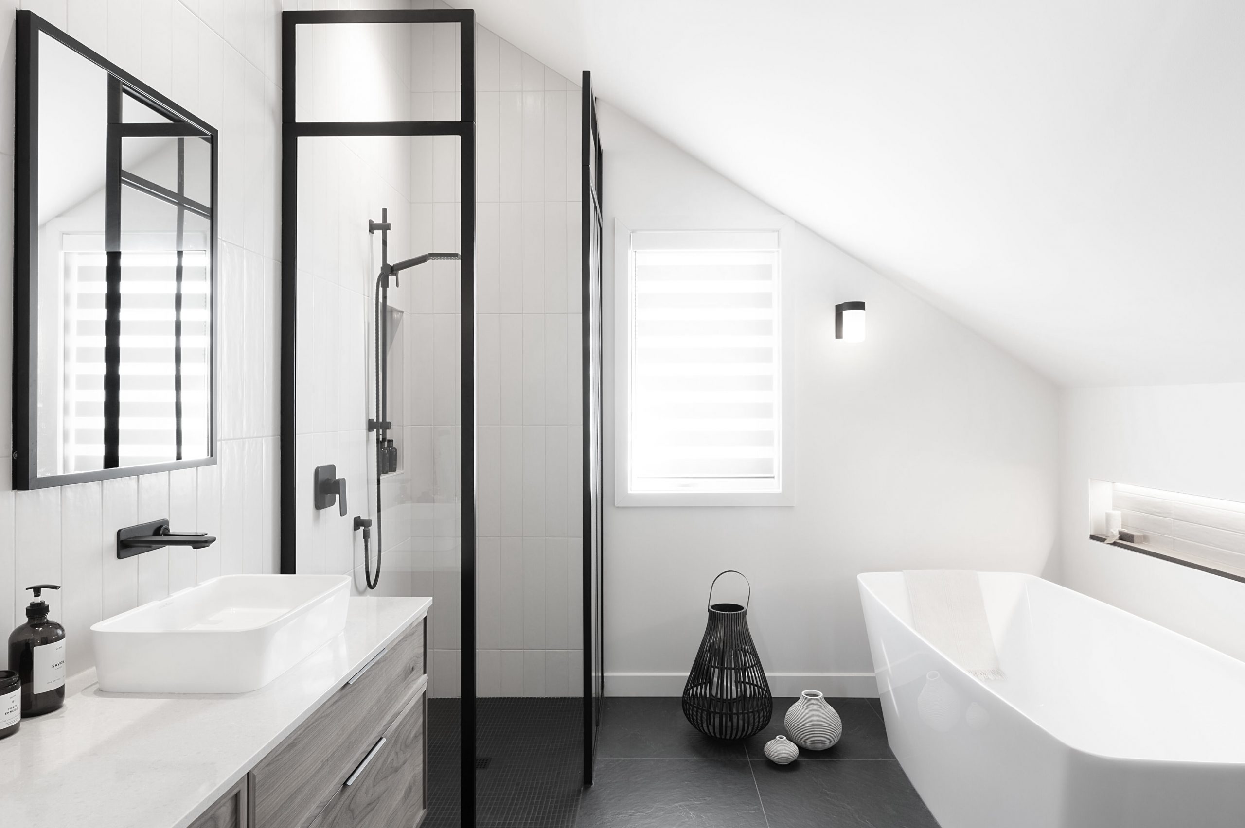 Salle de bain sous les combles avec douche vitrée et bain autoportant